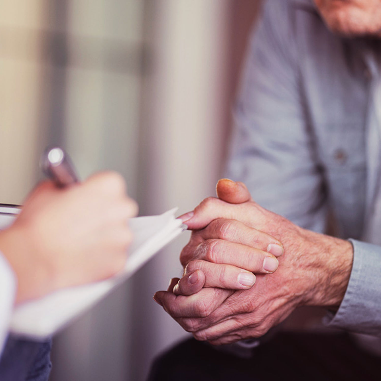 kvinna med skrivblock pratar med äldre man